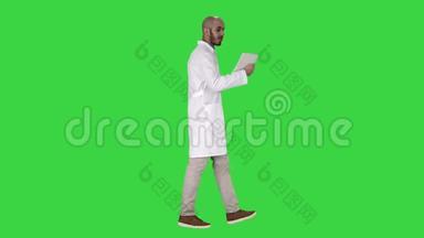 真诚的医生给他的病人打视频电话，在绿色屏幕上行走，Chroma键。
